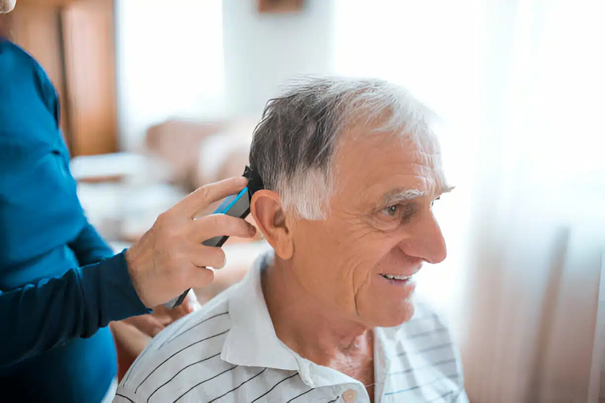 Ein Senior erhält einen Haarschnitt vor Ort